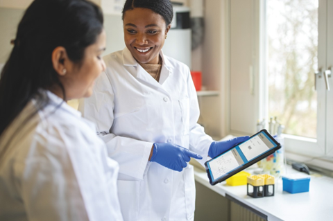 two women in a lab looking at a tablet